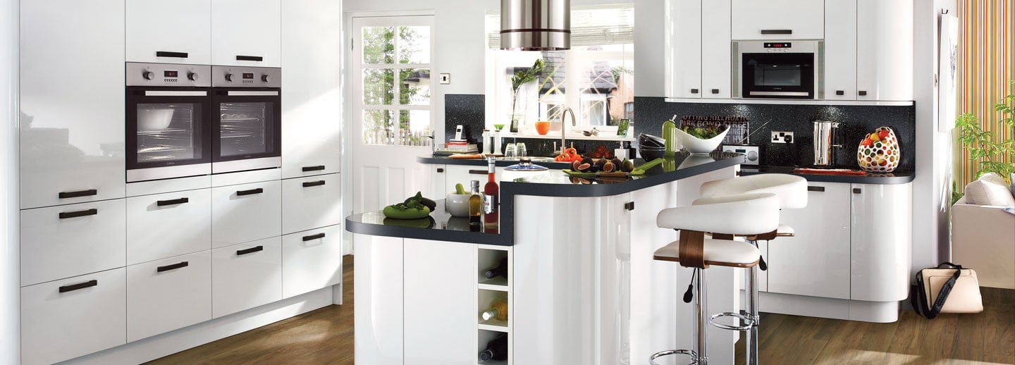A kitchen with white cabinets featuring a middle island with a breakfast bar.