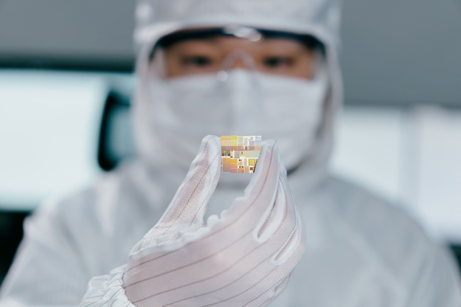 Scientist wearing PPE researchs chips in laboratory.