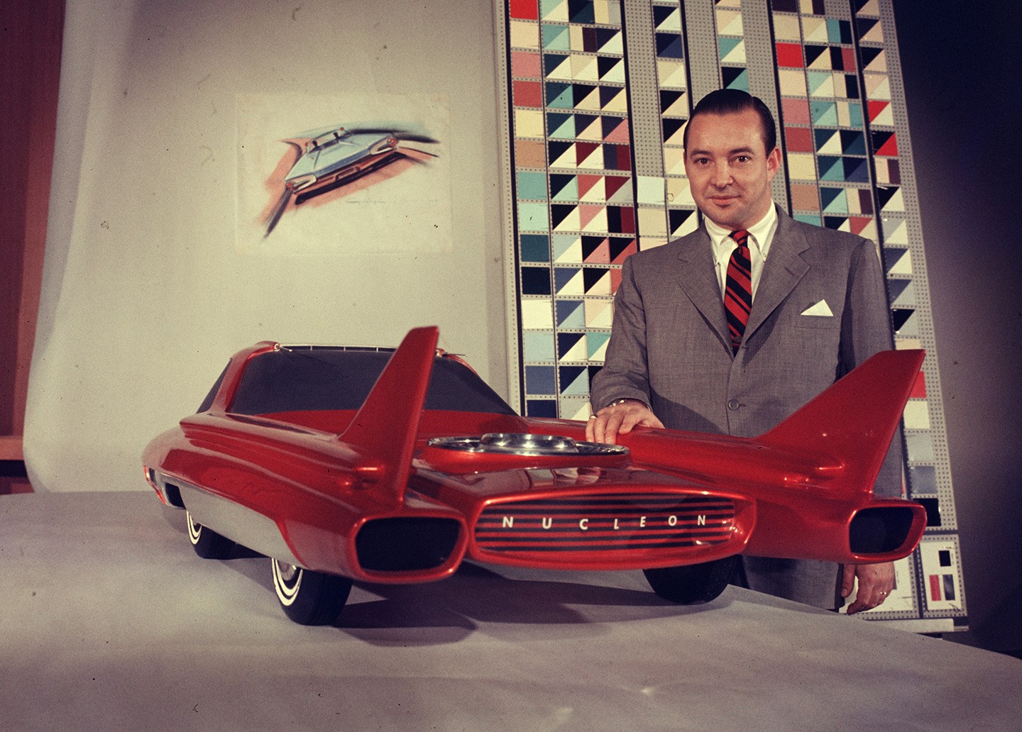 Car magnate, William Ford stand with his hand on a red model of Ford company