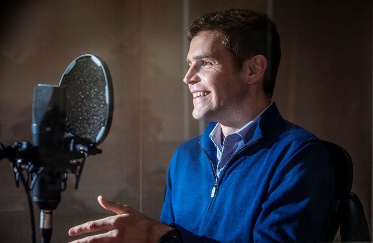 Ben Durrant faces a microphone in a recording booth during the recording of the Baillie Gifford podcast. 